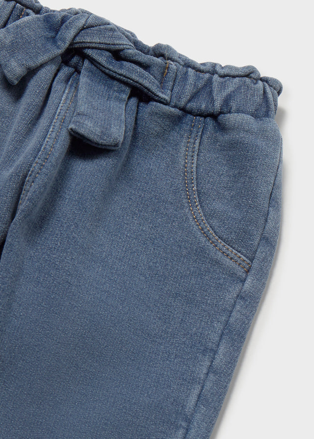 Dettaglio pantalone denim neonato Mayoral con vita elasticizzata fiocco e tasca anteriore