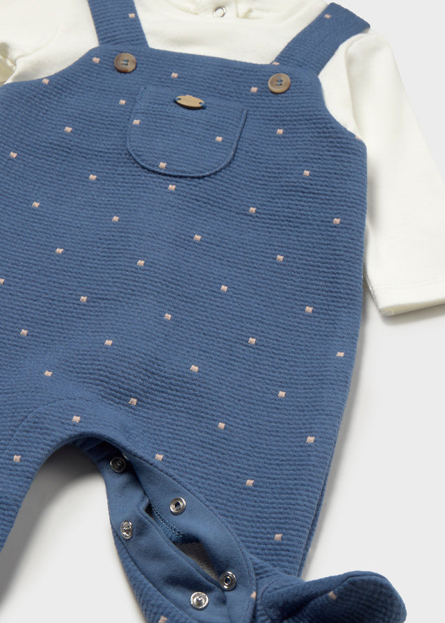 Dettaglio salopette neonato Mayoral in maglia blu con bretelle, taschina e piccoli pois