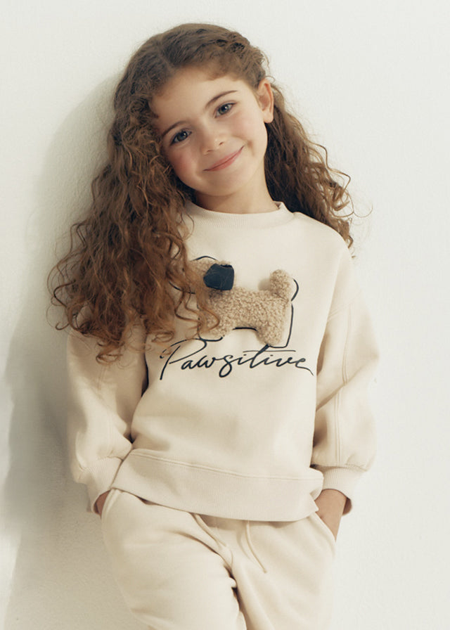 Bambina con completo Mayoral crema con cagnolino in rilievo e scritta Pawsitive
