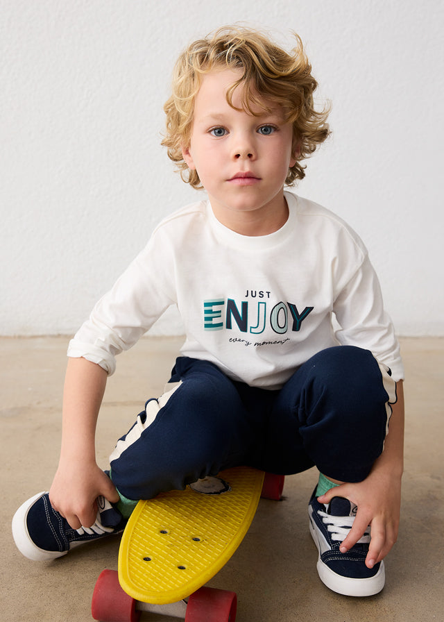 Bambino con maglia bianca Mayoral con scritta Just Enjoy Every Moment