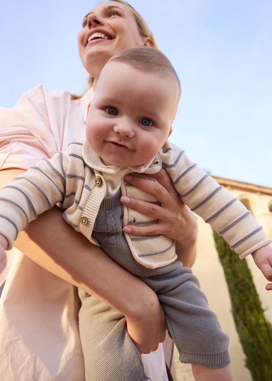 Completo 3 pezzi neonato Mayoral con salopette in maglia grigio chiaro, cardigan a righe e camicia bianca indossato