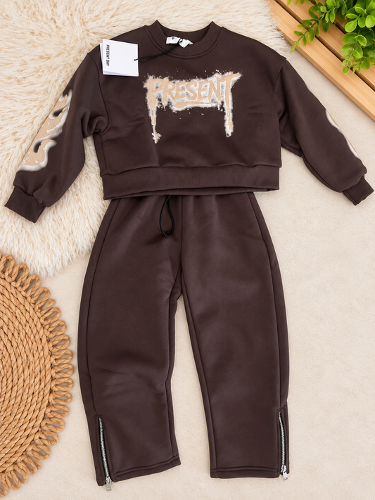 Completo tuta felpata moka da ragazzo Present Day composto da felpa girocollo con stampa grafica e pantalone lungo con zip alle caviglie.