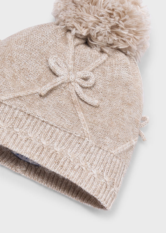 Dettaglio berretto Mayoral bambina con pompon e fiocco beige