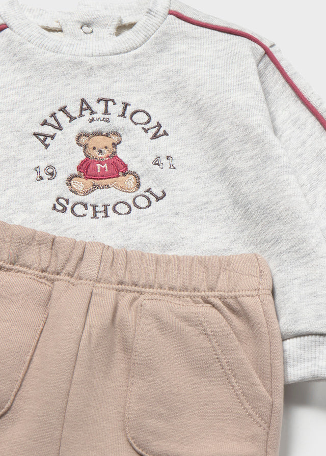 Dettaglio completo neonato Mayoral con felpa grigia Aviation School e pantalone beige