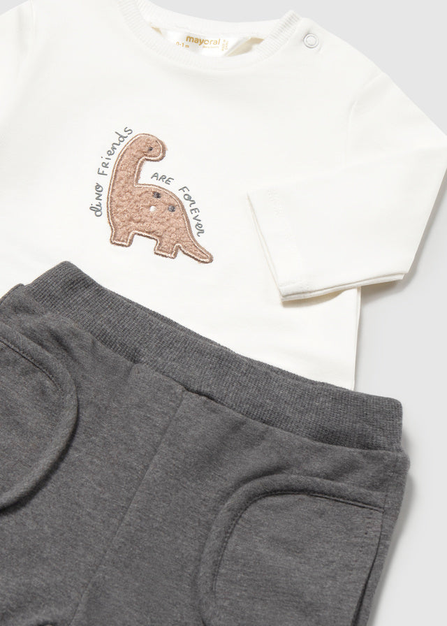 Dettaglio completo neonato Mayoral con maglietta bianca ricamata con dinosauro e pantalone grigio