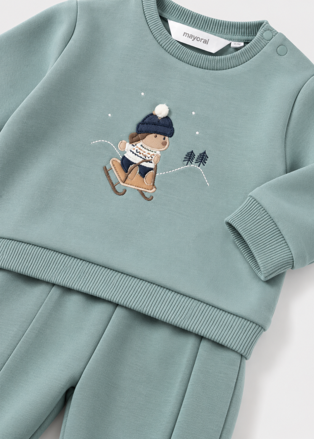 Dettaglio felpa neonato Mayoral verde acqua con applicazione bambino sullo slittino