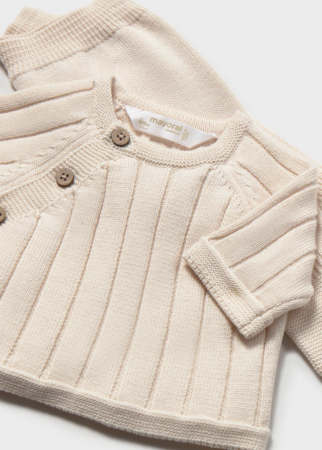 Dettaglio maglioncino neonato in maglia color écru con chiusura laterale e bottoni Mayoral