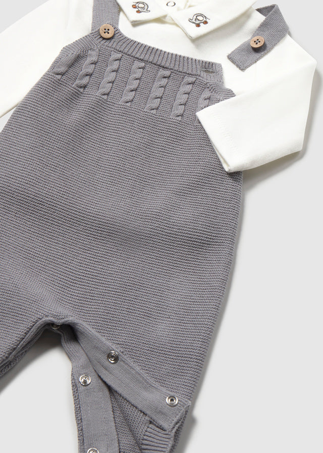 Dettaglio salopette neonato Mayoral in maglia con lavorazione a trecce e chiusura con automatici