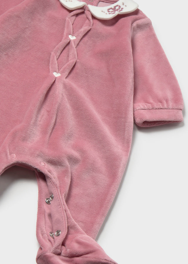 Dettaglio tutina neonata rosa in velluto con colletto bianco, bottoni a cuore e chiusura automatica Mayoral