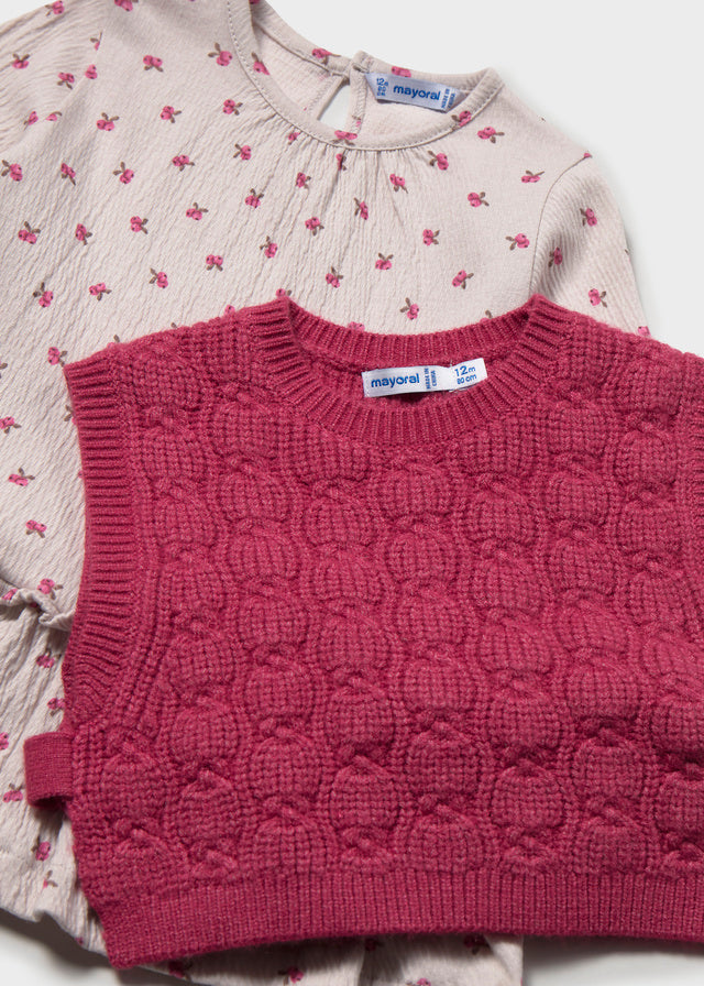 Dettaglio vestito Mayoral neonata con fantasia floreale e gilet bordeaux lavorato a trecce