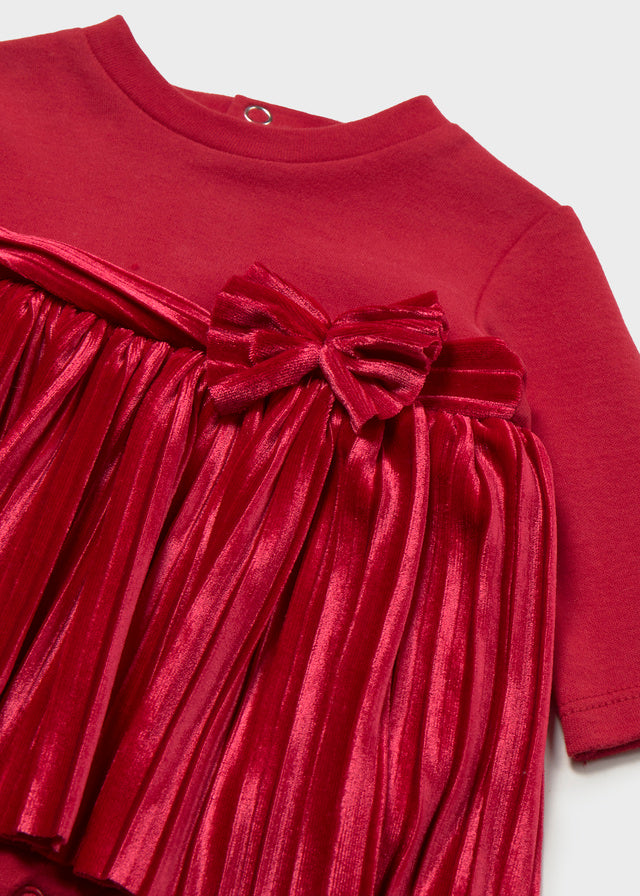 Dettaglio vestito neonata Mayoral con fiocco rosso e gonna plissettata luminosa