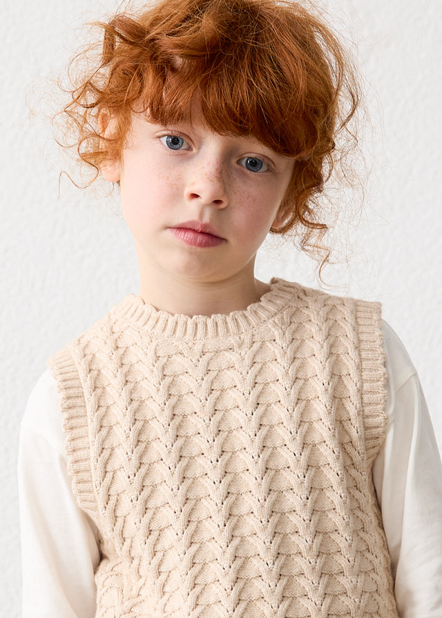Gilet bambina Mayoral beige indossato sopra una camicia bianca